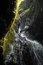 A canyoneer rappels down a waterfall in Tukad Api, Bali's Canyon of Fire