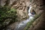 A canyoneer descending a waterfall by Gus Schiavon